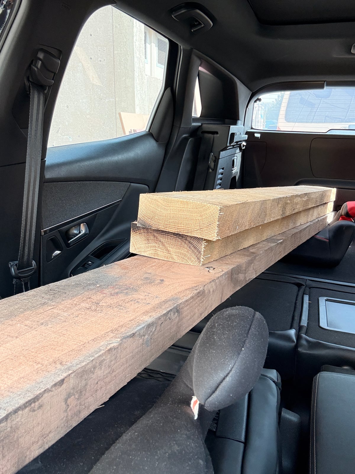 Rough boards laid across the folded seats of a car