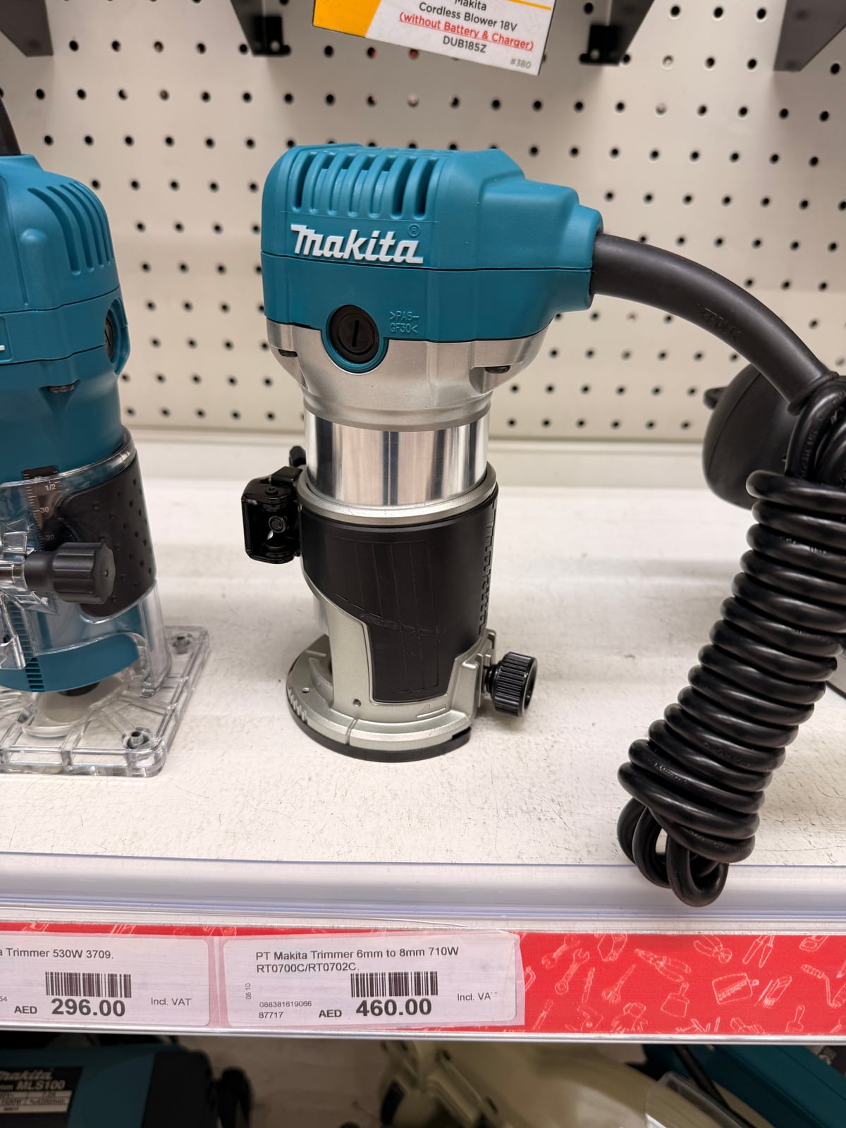A Makita compact router on a store shelf above its price tag