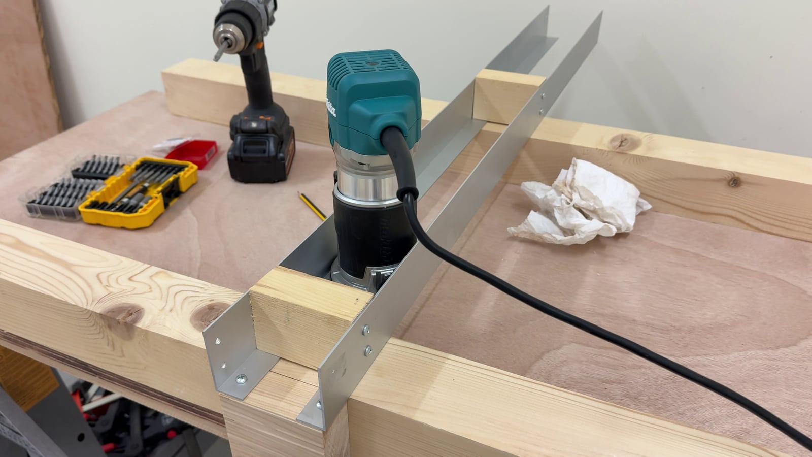 The finished router sled: a Makita router between two aluminium angle brackets spanning the 4x4 rails