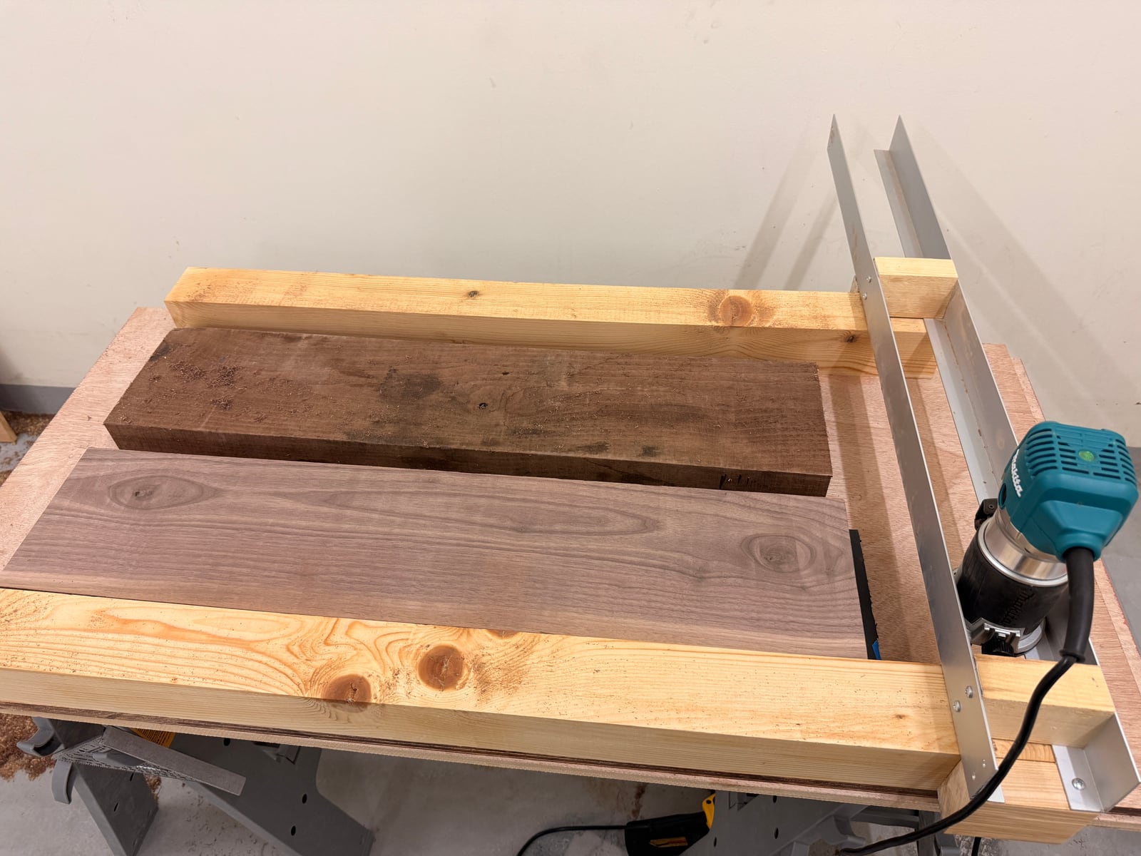 The router sled over two walnut boards, the router resting on its rails