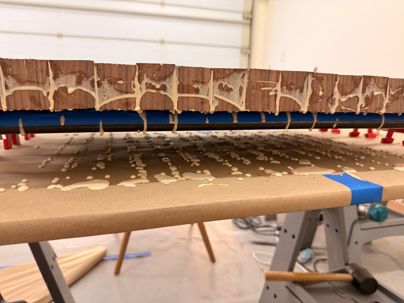 Glue dripping from the underside of the clamped board onto the bench