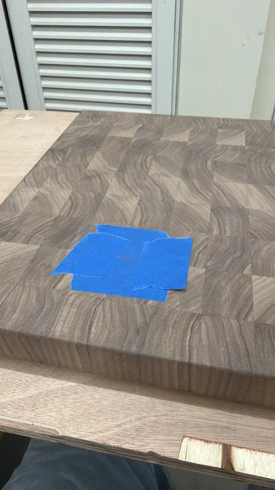 The board with a square of blue tape over a small repair