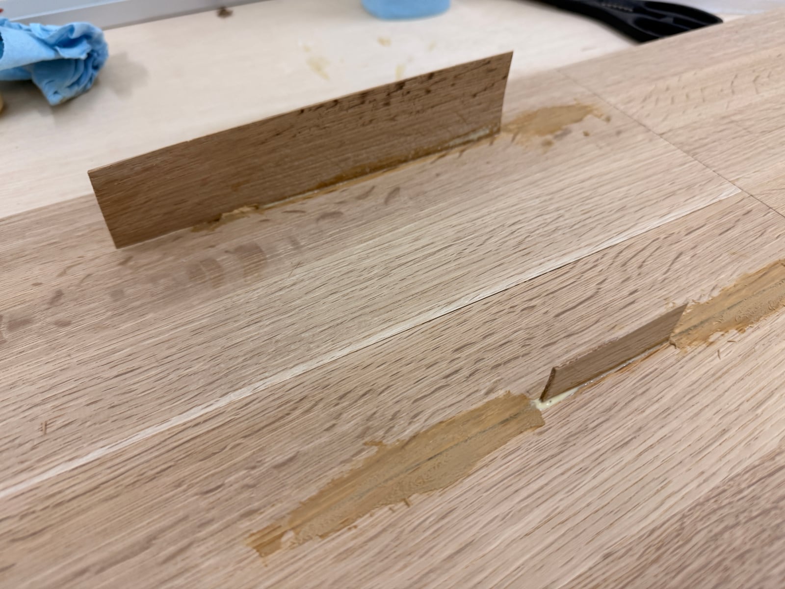 Glue and sawdust filling pressed into the seams of the oak panel