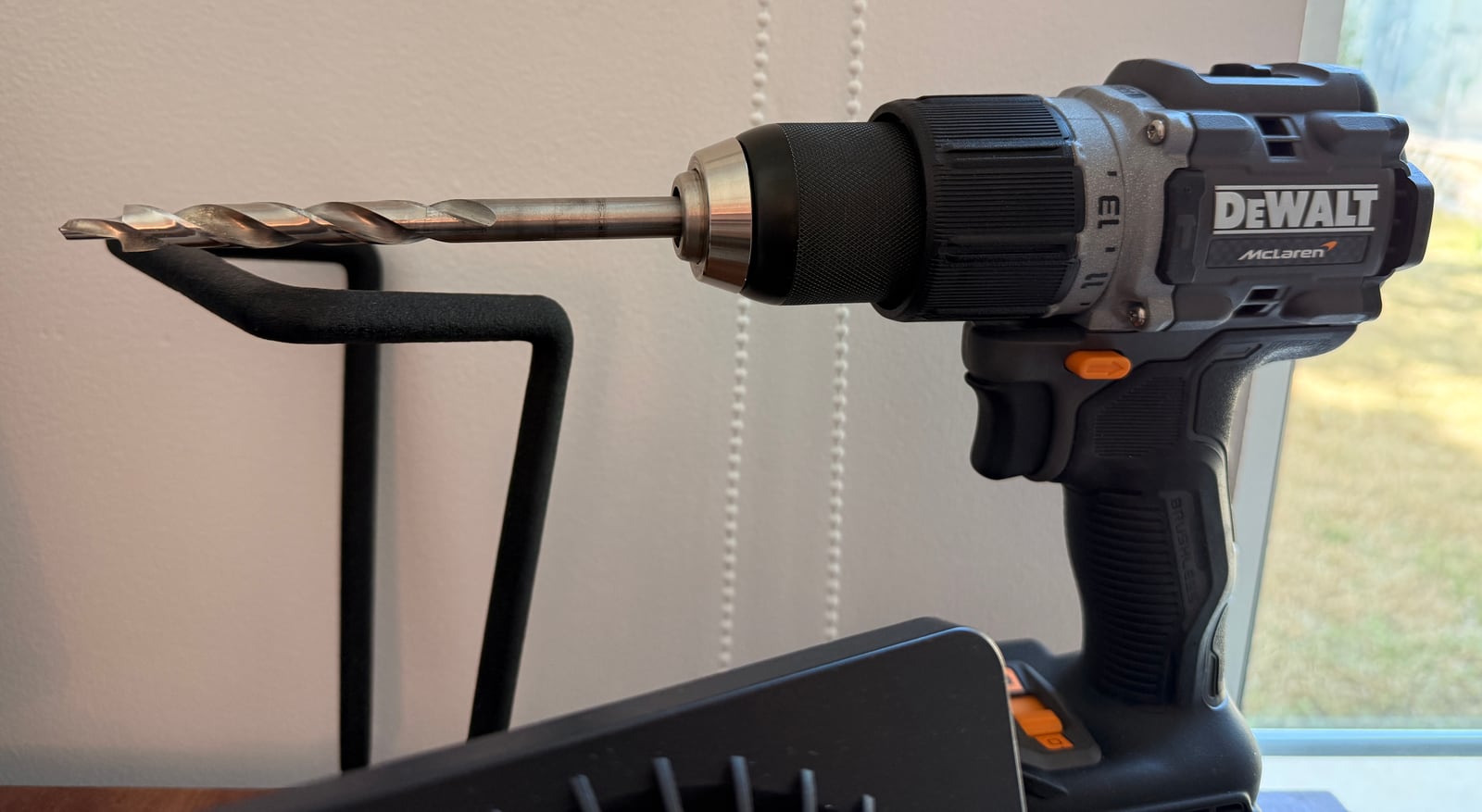 A grey DeWalt cordless drill with McLaren branding and a pocket hole bit in the chuck
