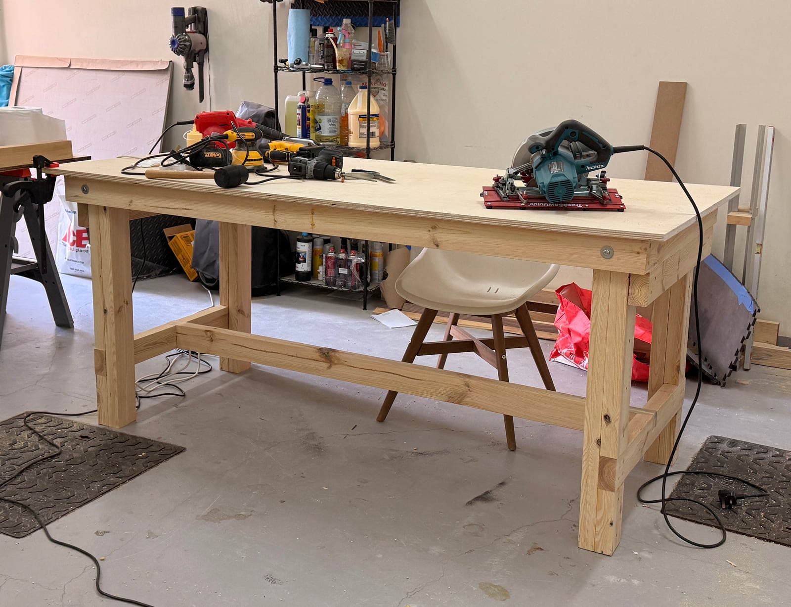 The finished folding workbench in the garage, a solid plywood-topped bench on folding legs