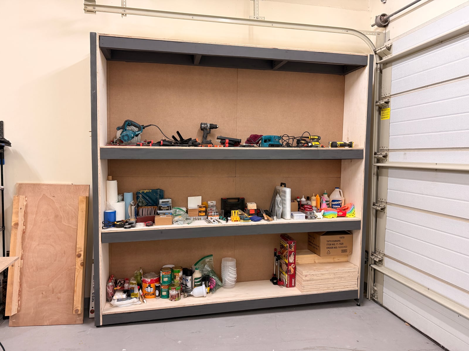 The finished shelves filled with tools, tins and boxes