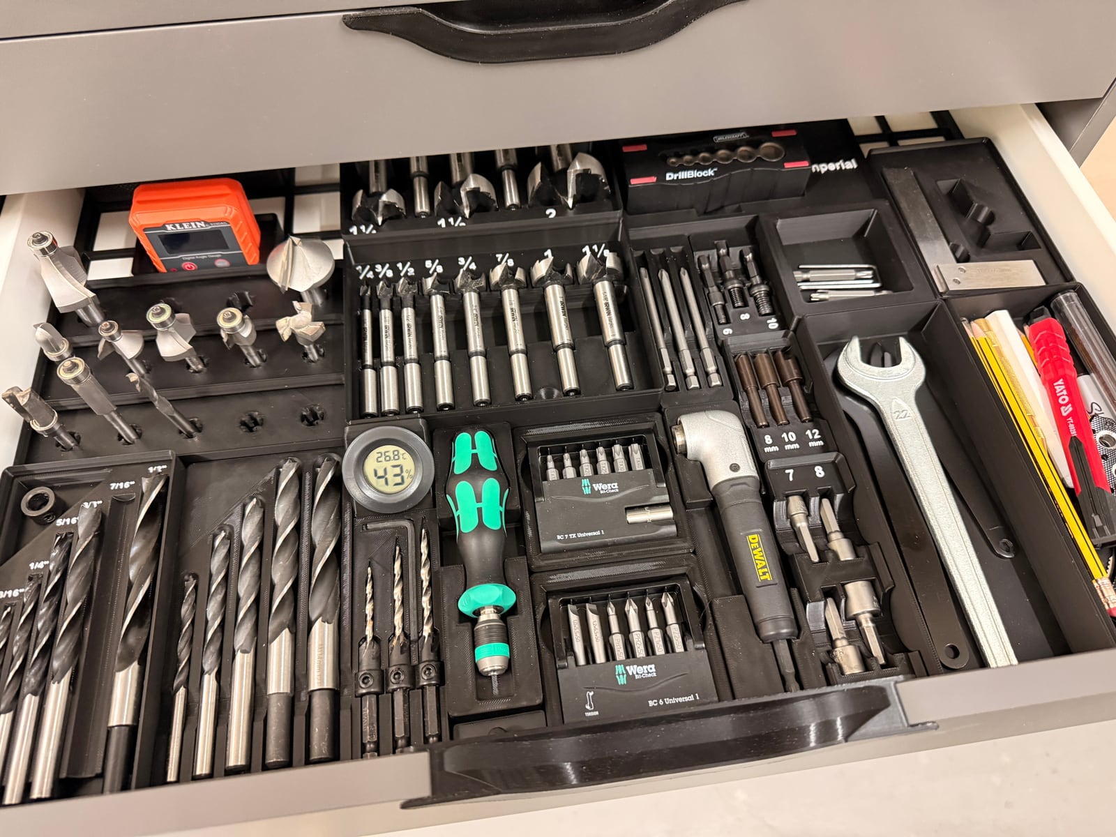 A drawer fitted with a black Gridfinity baseplate and printed bins holding drill bits, Forstner bits, router bits and screwdriver bits