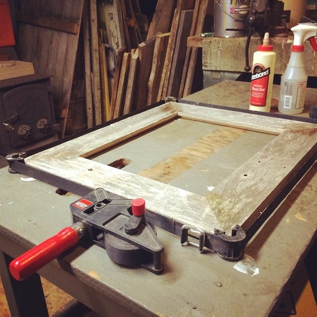 A band clamp pulling a frame together. One strap and a ratchet apply even pressure to all four corners at once, which is the whole reason it exists.