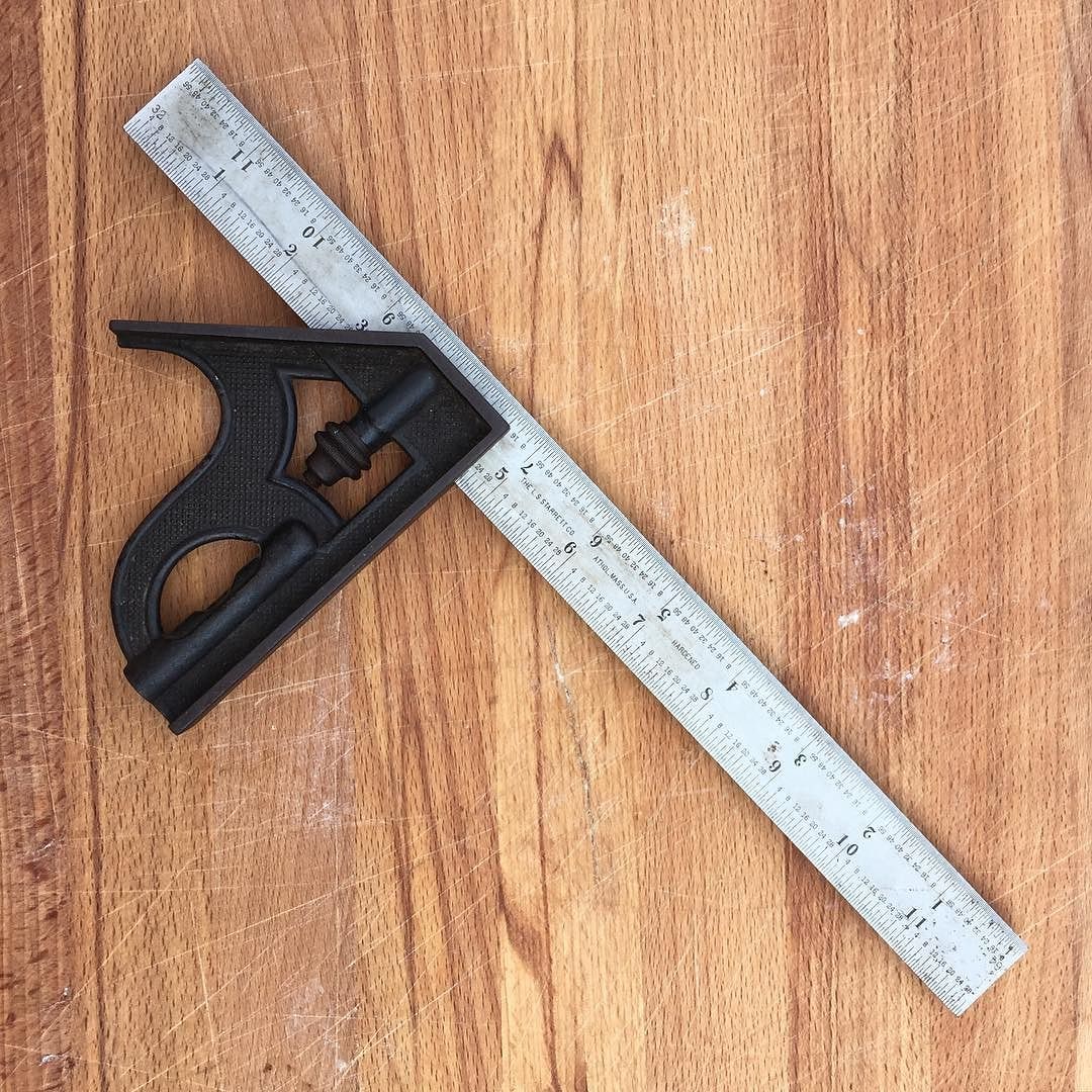A combination square -- the cast head registers a 90 degree face on one side and a 45 degree face on the other, and the rule slides through it and locks anywhere along its length.