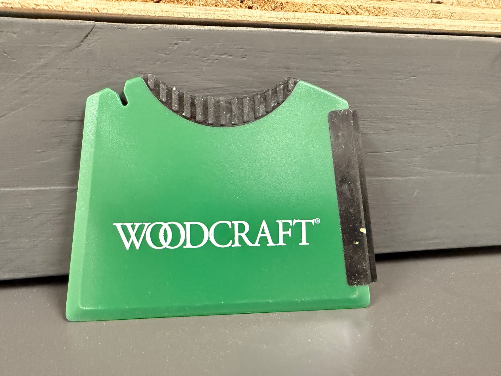 A silicone glue spreader -- notched comb edge on one side for spreading a measured film, flat squeegee edge on the other.
