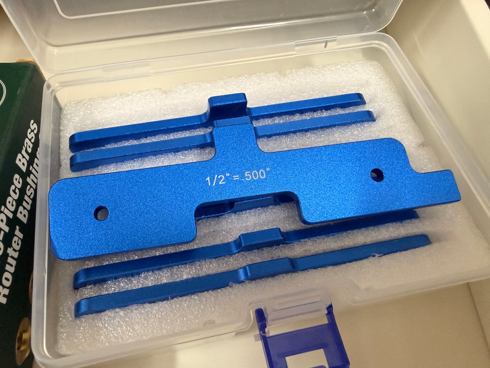 A set of anodised aluminium setup blocks, each step machined to a stated dimension and marked with its fraction and decimal equivalent.