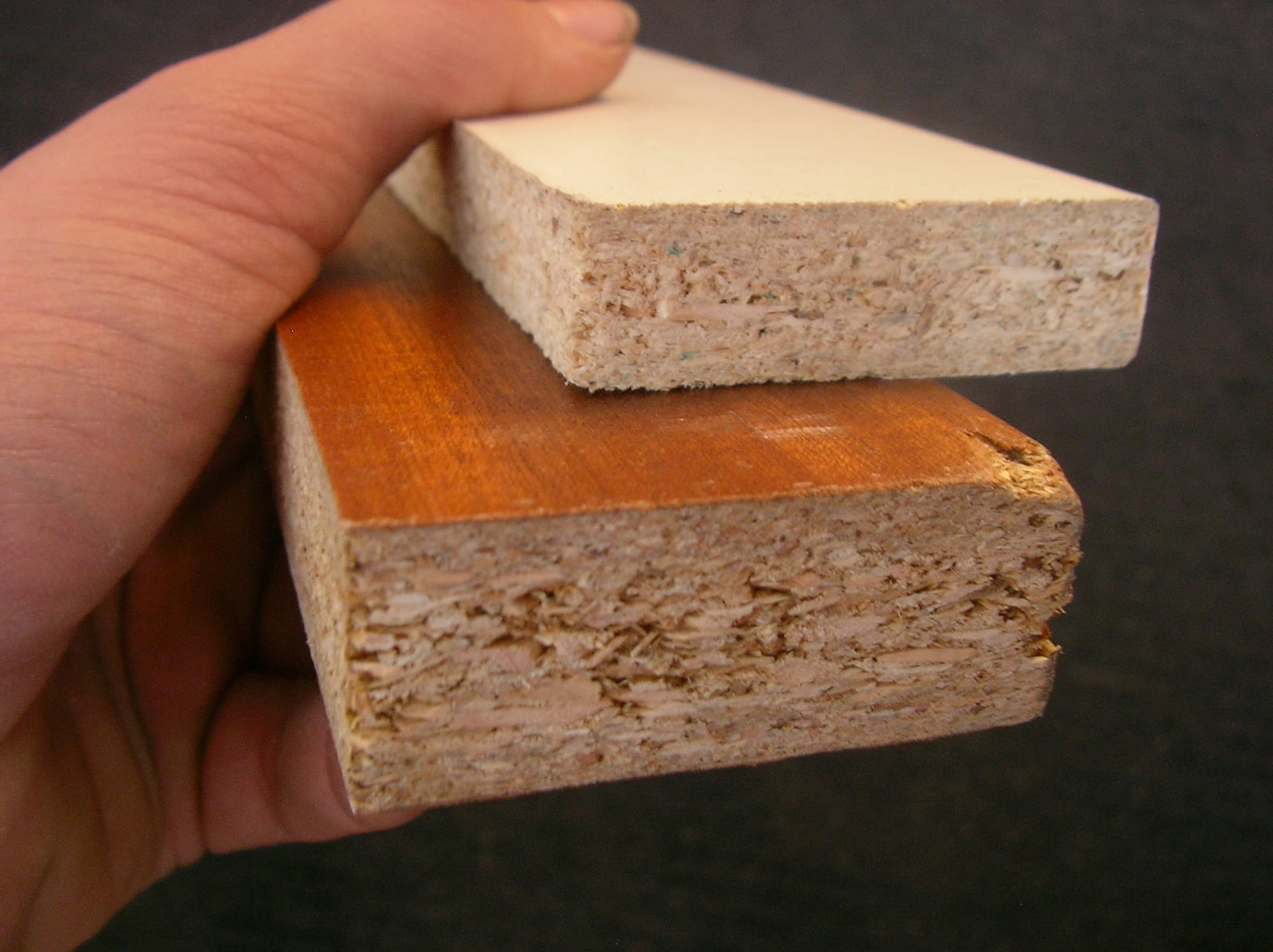Particleboard in section -- wood chips and resin pressed into a board. The edge is the giveaway, and the reason it holds screws so poorly.