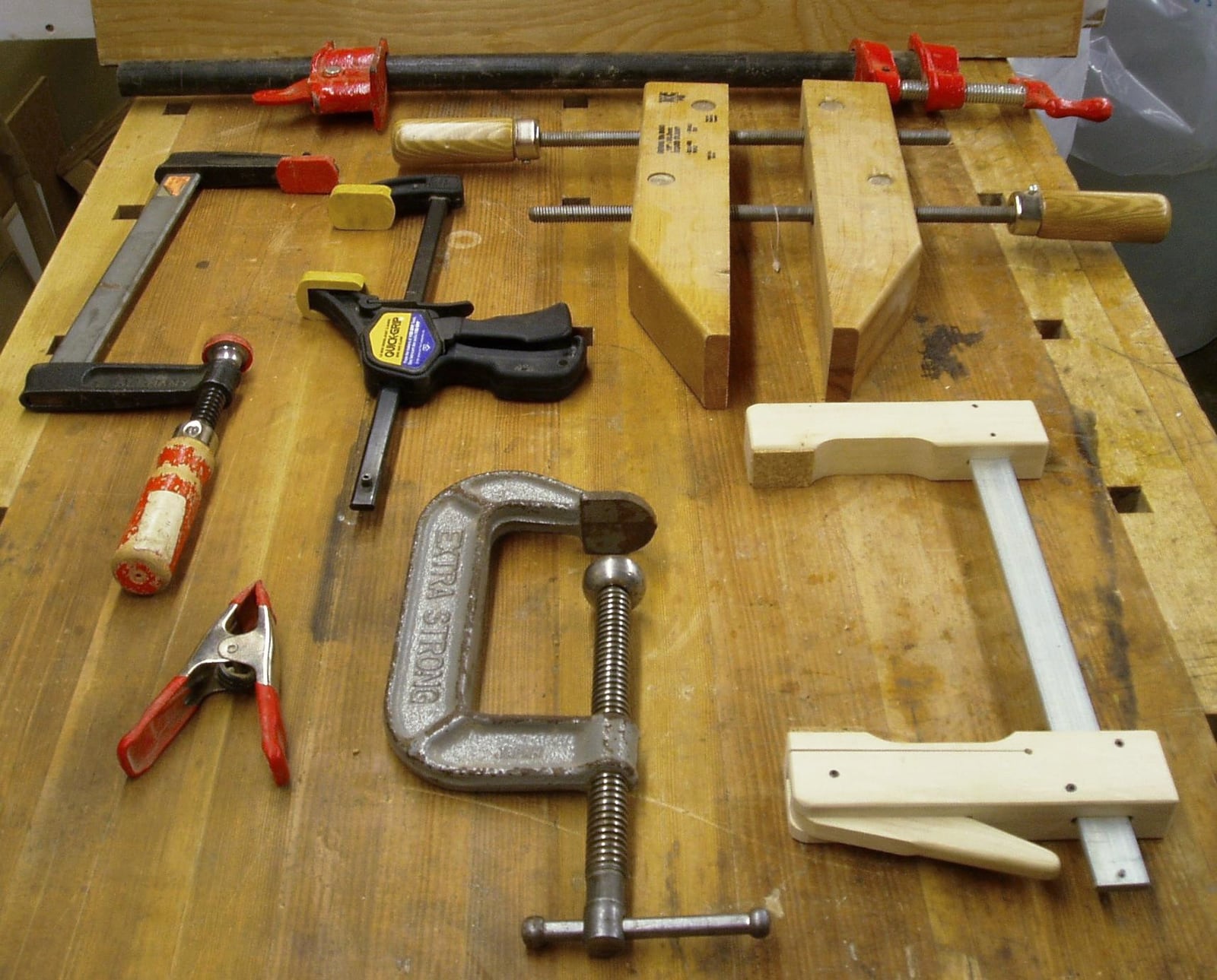 A glue-up under whatever reached -- C-clamp, F-clamps, a handscrew and a spring clamp. Clamp choice is usually about access, not force.