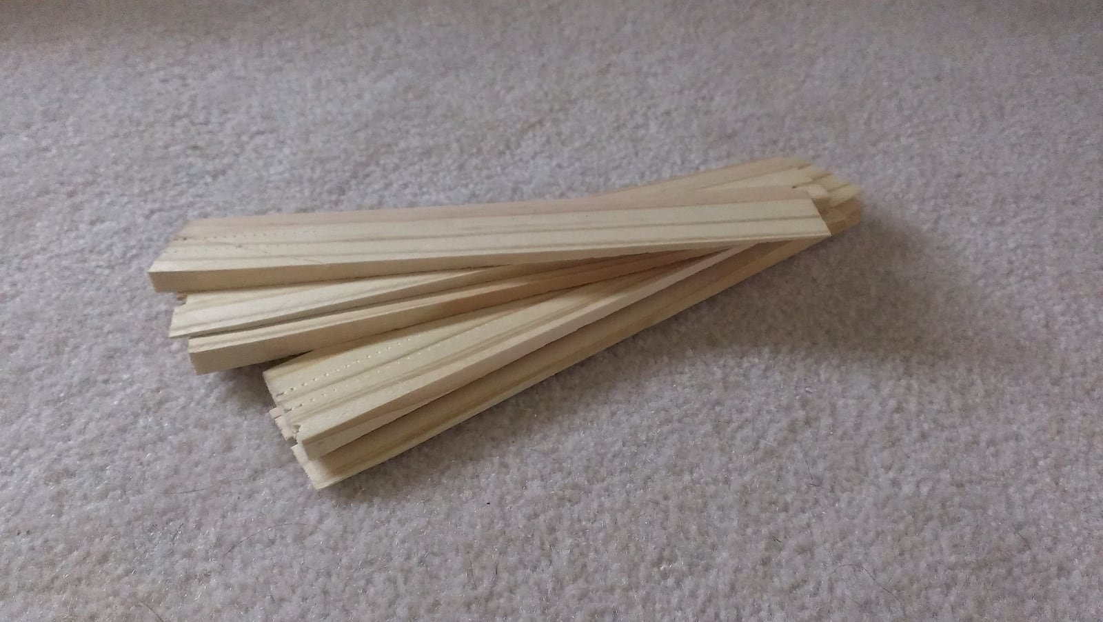 A bundle of tapered shims. Sliding two past each other in opposite directions gives any thickness you want without cutting anything.