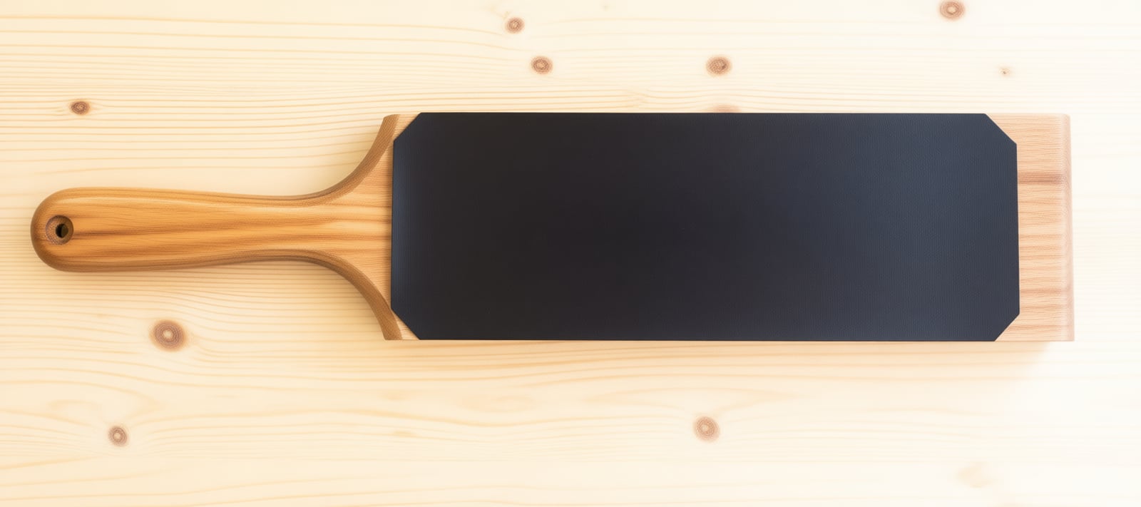 A leather strop. Loaded with compound and drawn edge-trailing, it polishes off the wire edge a hone leaves behind -- the difference between sharp and actually sharp.
