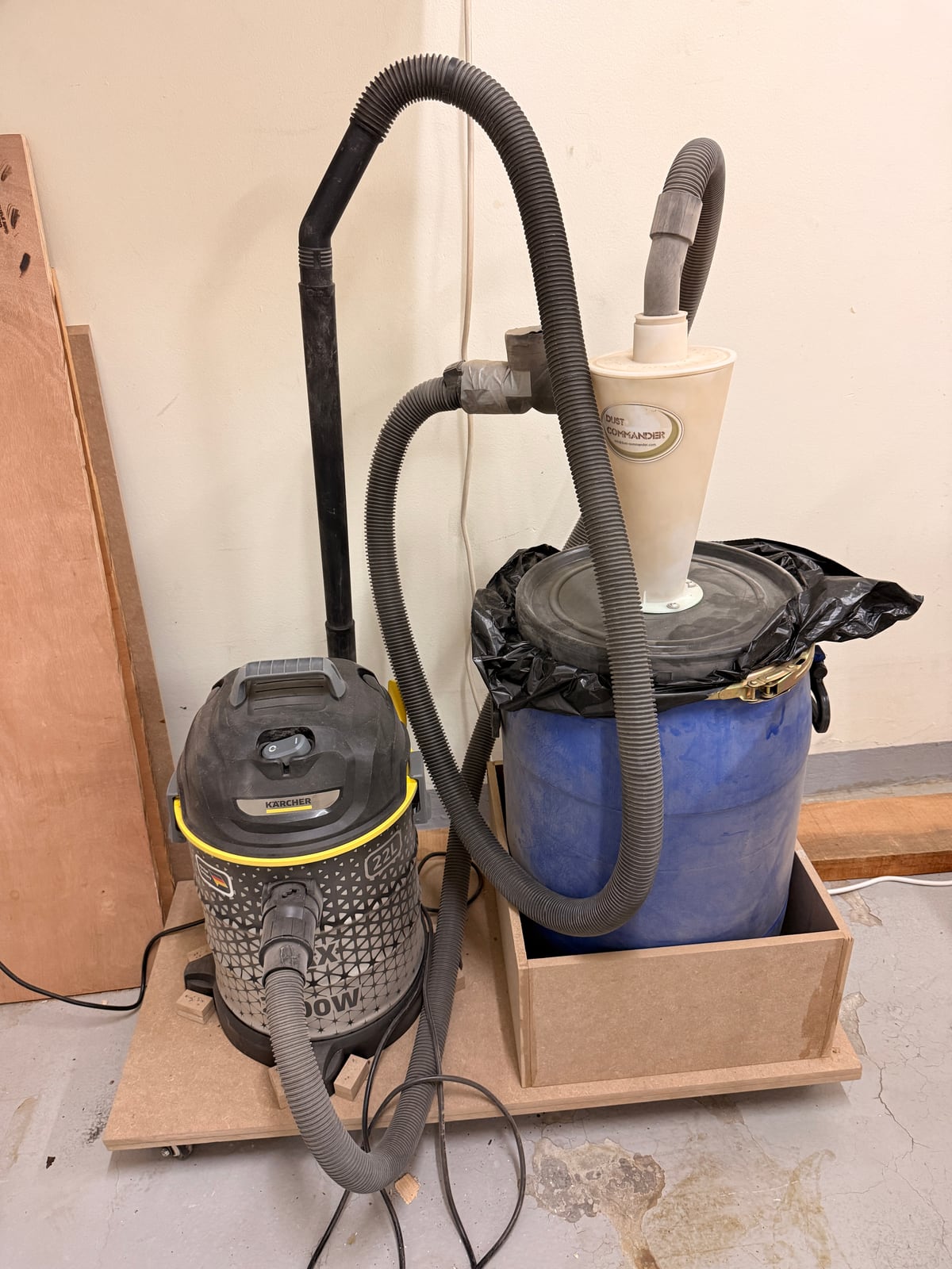A shop vacuum paired with a cyclone separator over a drum. The cyclone drops the bulk of the chips into the drum before they ever reach the vacuum, so the filter stops clogging every ten minutes.