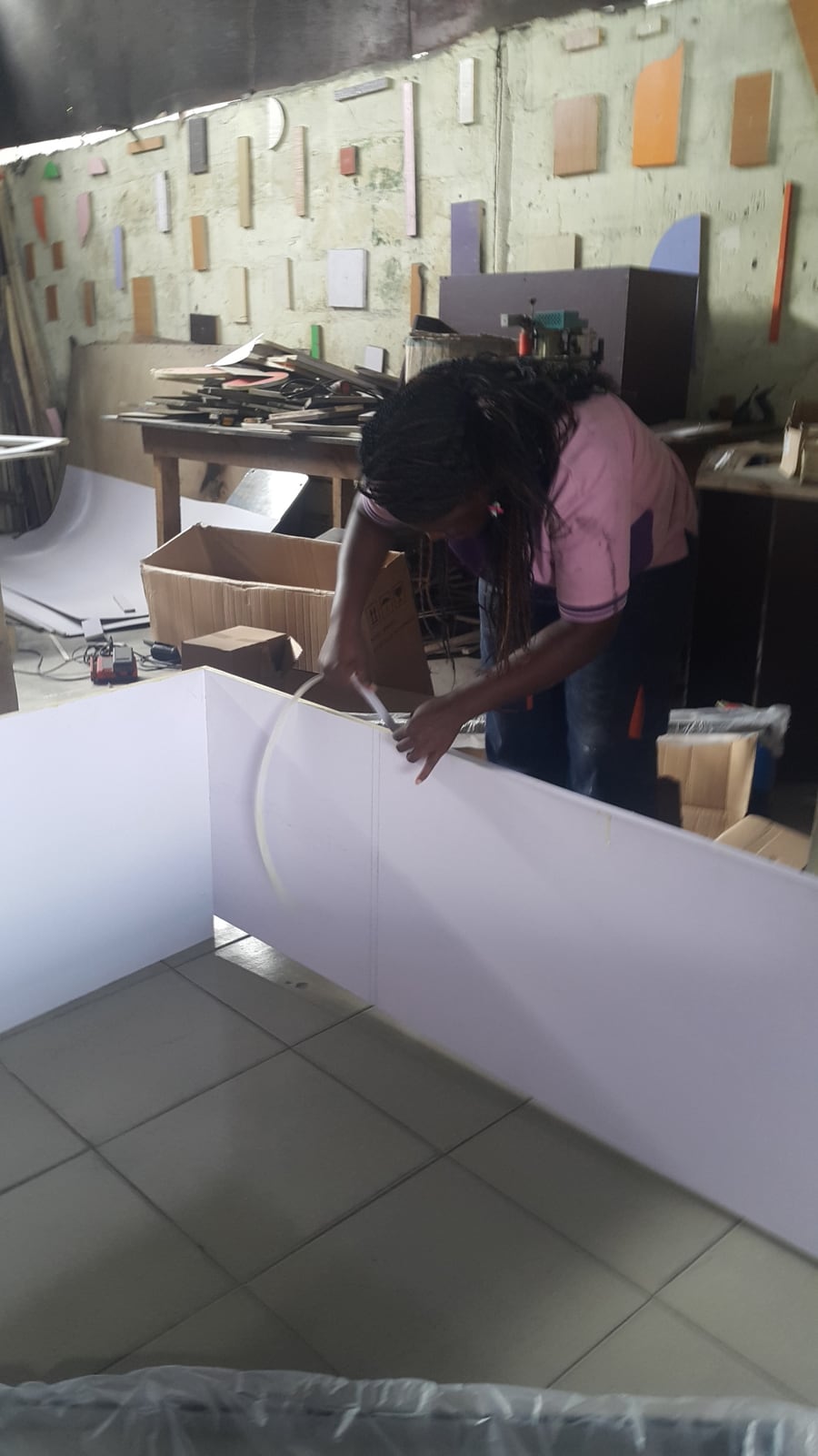 Edge banding a workpiece by hand in a furniture workshop